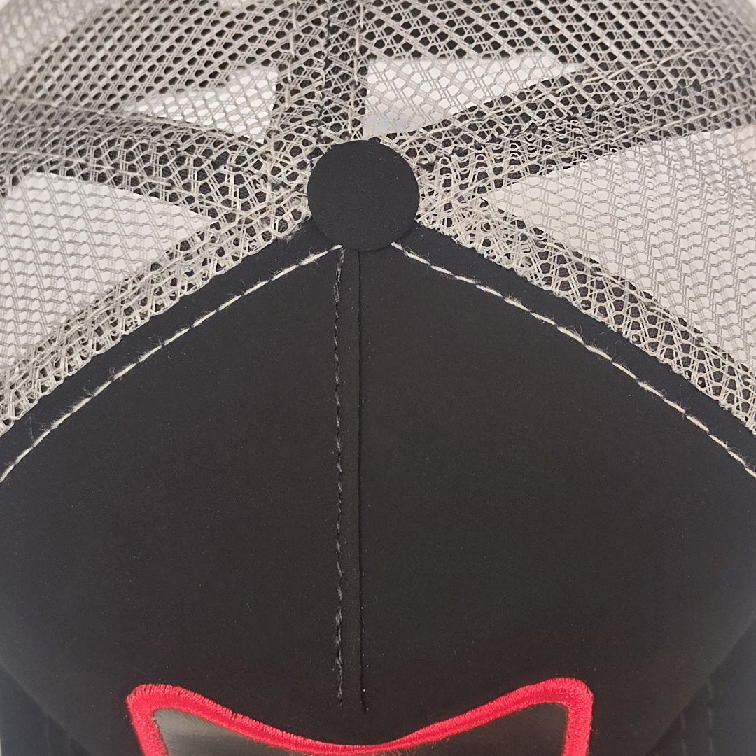 gorra negra con malla gris y parche rojo