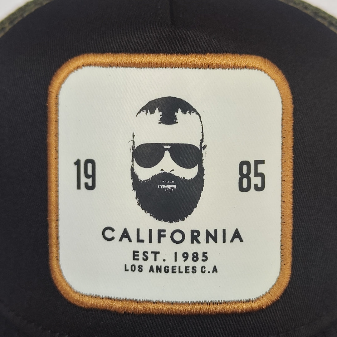 gorra negra con malla verde y parche blanco
